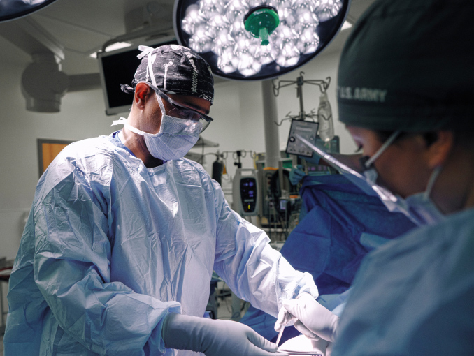 An Army Surgeon performing a surgical procedure in an operating room