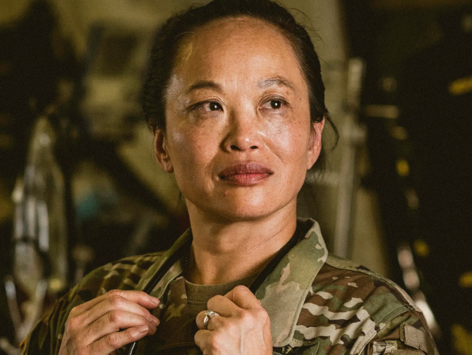 Closeup of a female Army Physician in combat uniform holding her stethoscope