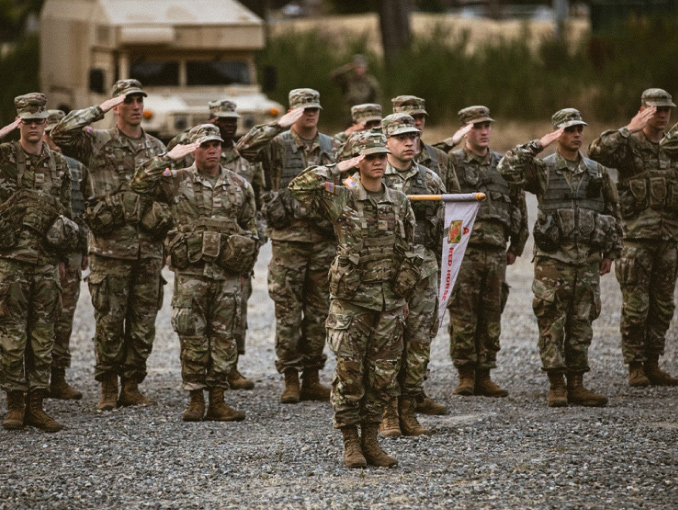 A group of officer candidates outdoors saluting in formation