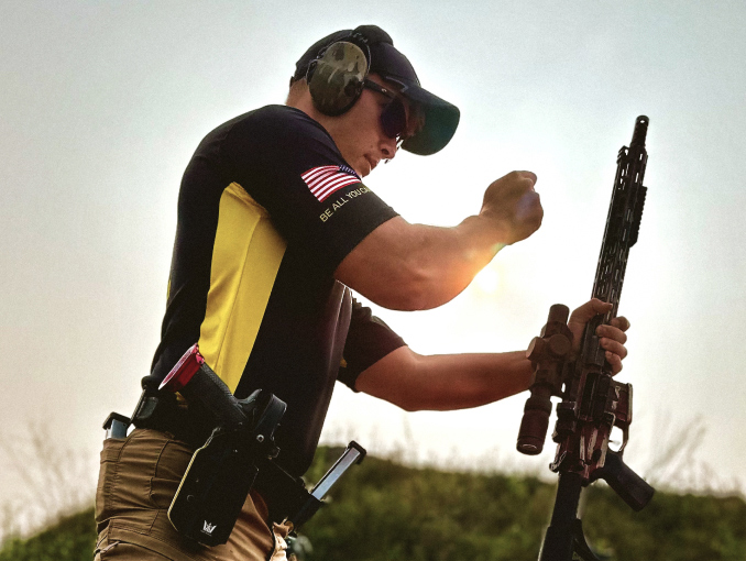 An Army marksmanship instructor standing outside with a rifle 