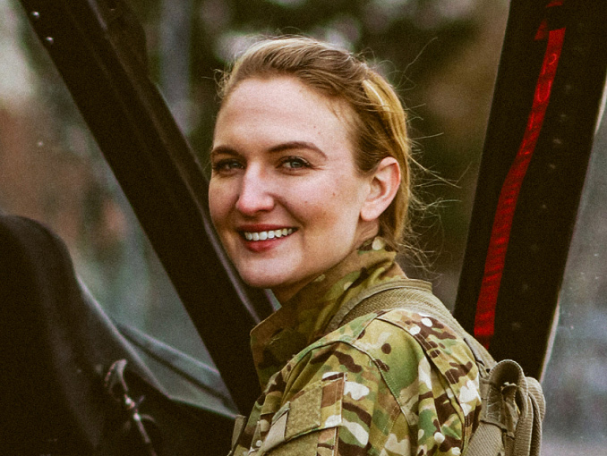 Female Army pilot climbing into the cockpit of a helicopter