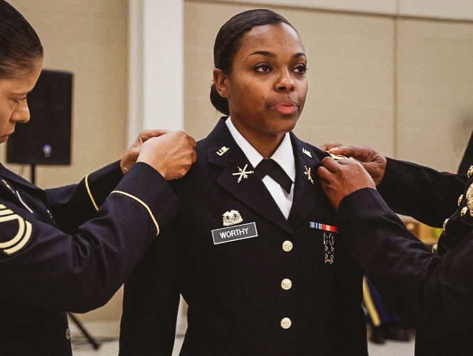 A male Officer Candidate is pinned by his father during an Officer Candidate School graduation ceremony. 