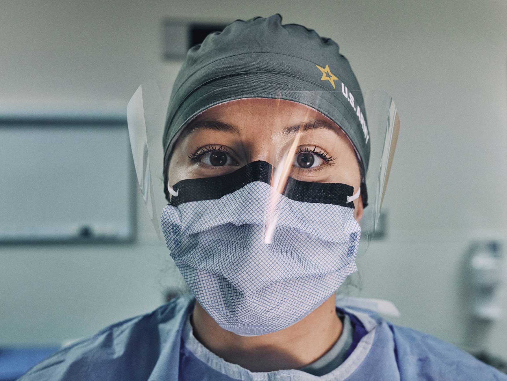 An Army health care worker wearing face masks and a face shield