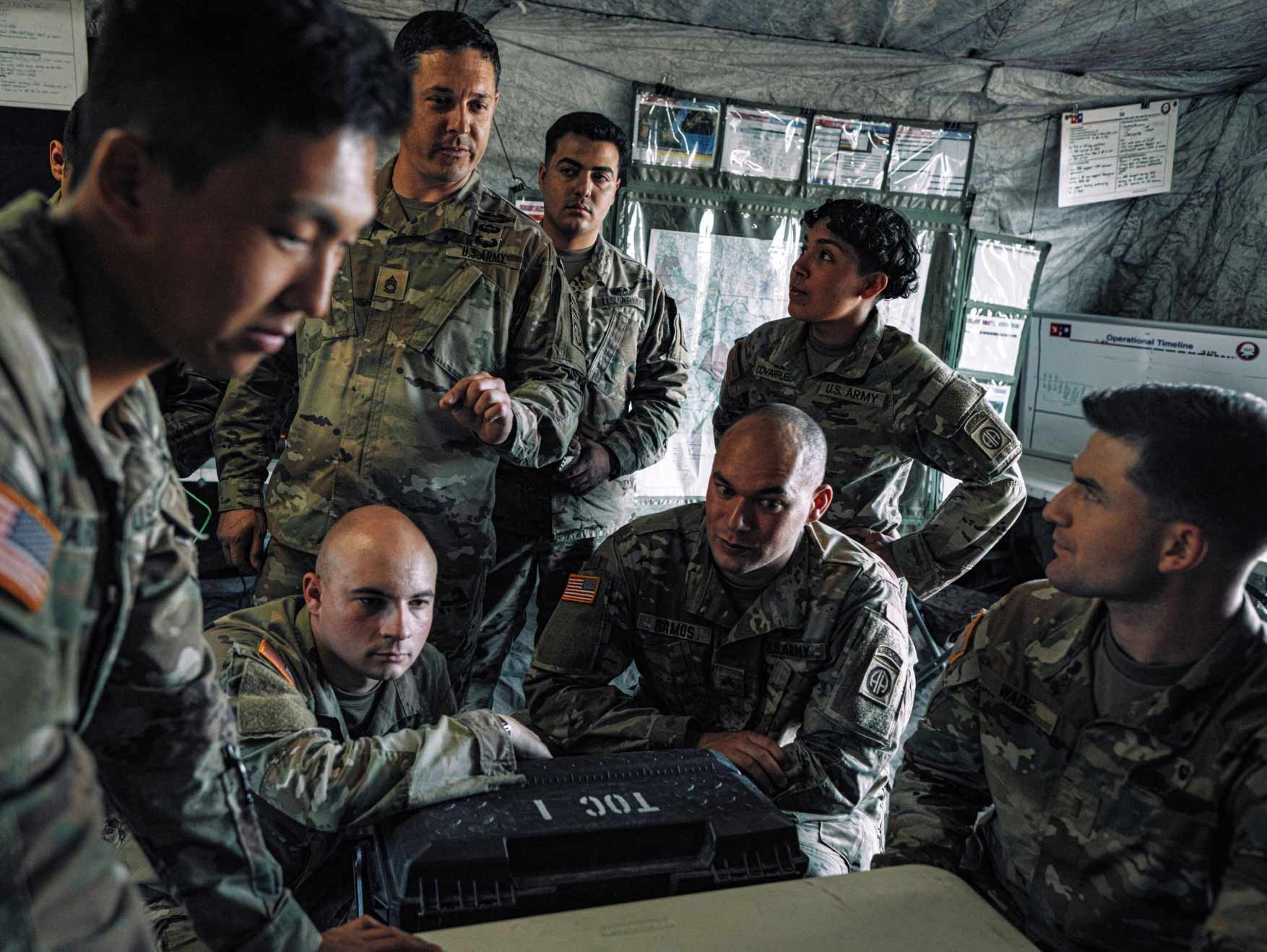 A group of six Soldiers in combat uniform in an Army tent