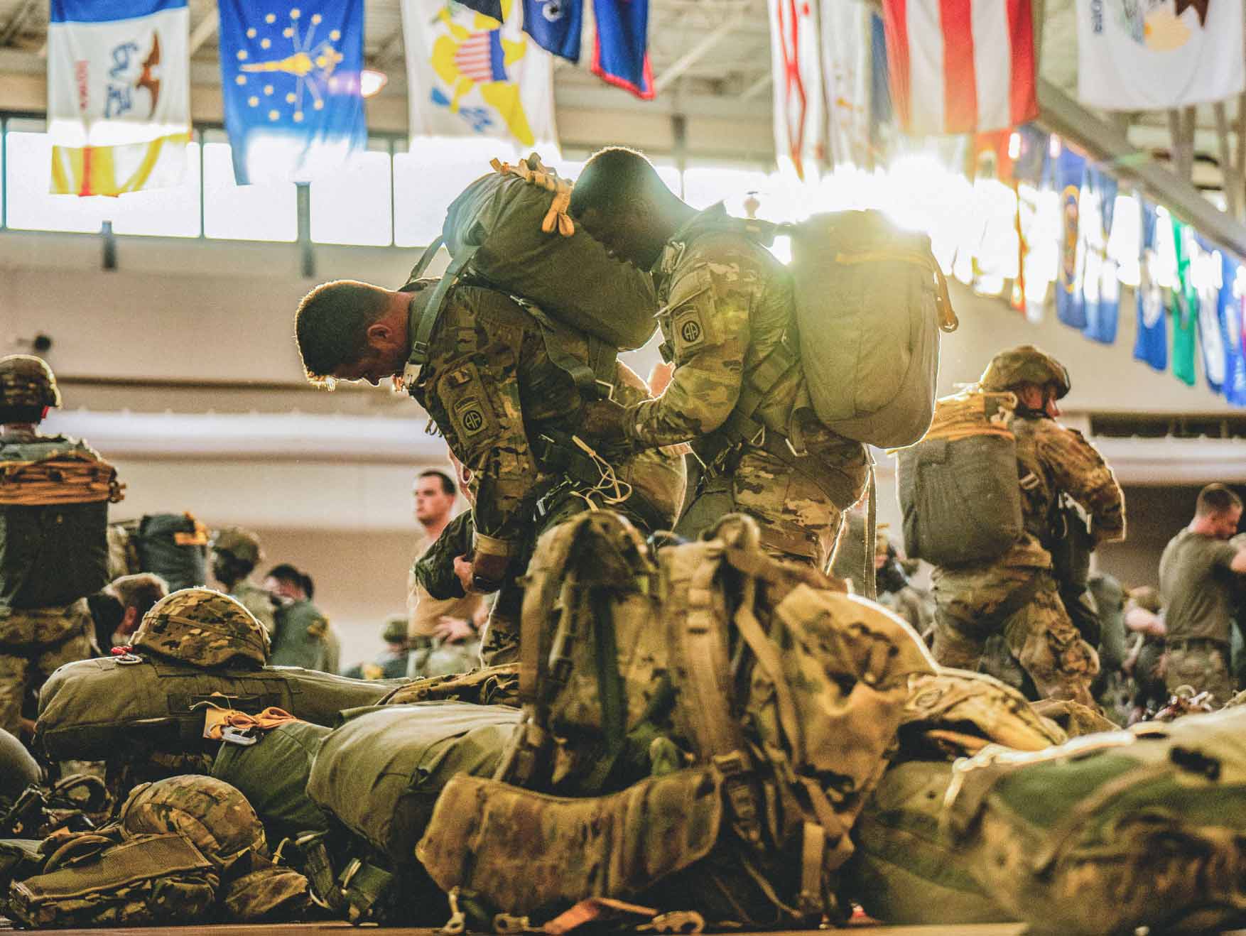 Army Paratroopers buddy rig their parachutes as they prepare for a jump