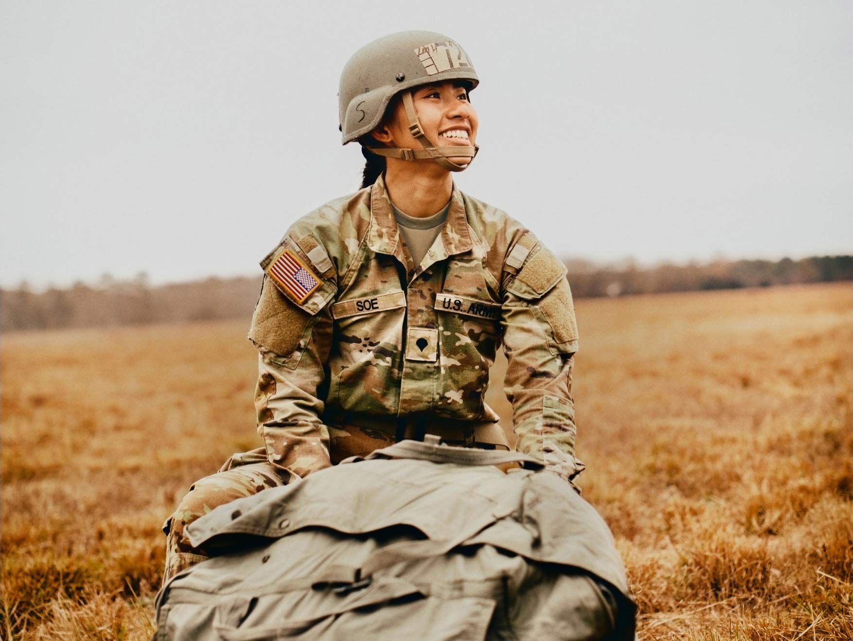 A female Soldier carrying a bag of equipment