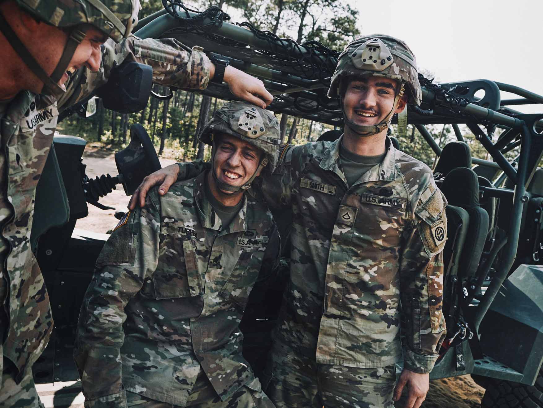 Two Soldiers in combat uniform smile for a photo